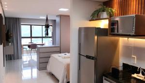 a kitchen with a refrigerator and a bed in a room at Lindo Ap Studio em Bananeiras in Bananeiras