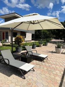 a patio with two chairs and an umbrella at Exclusive Farm Getaway in Lusaka