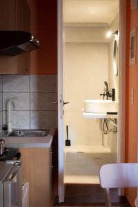 une petite cuisine avec un évier et un évier dans l'établissement RYB Colour Apartment, à Patras