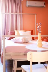 a bedroom with a bed and a table with flowers on it at RYB Colour Apartment in Patra
