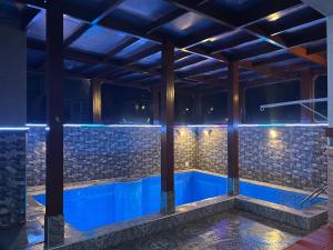een zwembad in een huis 's nachts met blauwe lichten bij Villa Nador in Nador