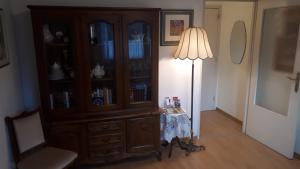 a large wooden cabinet with a table and a lamp at Klipfel Little Venice in Colmar