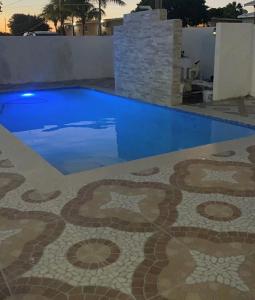 a swimming pool with a tile floor and blue water at Curacao Cozy Apartment in Willemstad