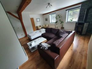 a living room with a brown couch and a bed at Kornhaus - schöne Ferienwohnung mit Pool, Kamin und Terrasse in Göttingen