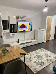 a living room with a table and a flat screen tv at EDA apartment in Bistriţa