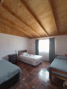 1 dormitorio con 2 camas y techo de madera en Parcela Sant Llorenç en Cabrero