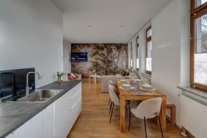 uma cozinha e sala de jantar com uma mesa de madeira e cadeiras em Kaza Guesthouse, centrally located 2 & 3 bedroom Apartments in Augsburg em Augsburg