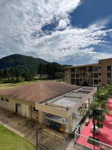 a large building with a large field in front of it at Condado Aldeia dos Reis 311 in Mangaratiba