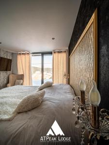 - une chambre avec un grand lit et une grande fenêtre dans l'établissement ATPeak Lodge Maison de Montagne d'exception, à Xonrupt-Longemer