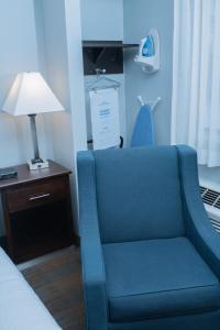 einem blauen Stuhl neben einem Bett in einem Zimmer in der Unterkunft AmericInn by Wyndham Madison WI in Madison