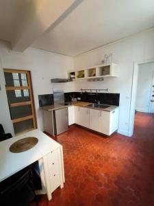 cocina con armarios blancos y suelo rojo en T2-Avignon - centre historique, en Aviñón