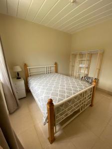 1 dormitorio con 1 cama con edredón blanco en Aconchego Petrópolis, en Petrópolis