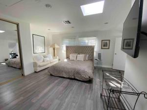 a bedroom with a bed and a couch and a television at Universal Studios 2 Mile Retreat in Los Angeles