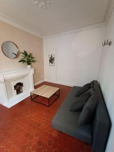 sala de estar con sofá y chimenea en T2-Avignon - centre historique, en Aviñón