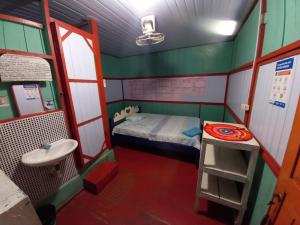 Habitación pequeña con cama y lavamanos en Hostal tachiwa, en Puerto Nariño