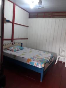 una piccola camera con un letto e una sedia bianca di Hostal tachiwa a Puerto Nariño