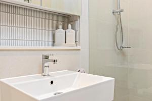 uma casa de banho branca com um lavatório e um chuveiro em 3 Bedroom Apartment over looking Newcastle em Newcastle