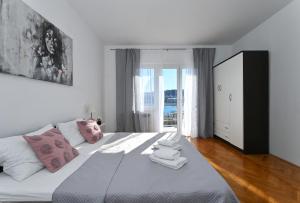 Holiday house Vukman في تروغير: غرفة نوم مع سرير أبيض كبير مع وسائد وردية