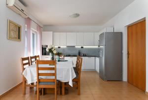 eine Küche mit einem Tisch mit Stühlen und einem Kühlschrank in der Unterkunft Holiday house Vukman in Trogir