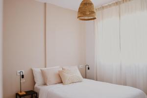 a bedroom with a white bed and a window at Casa Mahalo - Modern Apartment with Pool, Minutes from Spectacular Beaches in Parque Holandes