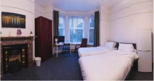 a hotel room with two beds and a fireplace at Howard House in Southampton