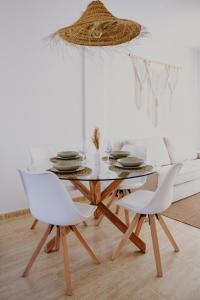 comedor con mesa de cristal y 2 sillas blancas en Casa Mahalo - Modern Apartment with Pool, Minutes from Spectacular Beaches, en Parque Holandes
