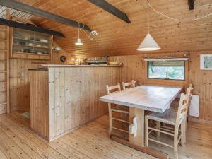eine Küche mit einem Tisch und Stühlen in einer Hütte in der Unterkunft 4 person holiday home in Martofte in Martofte