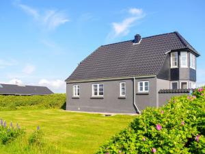 a gray house with a black roof on a yard at Holiday home Lemvig IV in Ferring