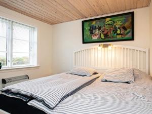 a bedroom with two beds and a painting on the wall at Holiday home Lemvig IV in Ferring