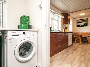 a kitchen with a washing machine in a room at Holiday home Lemvig IV in Ferring