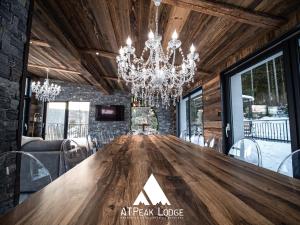 Cette chambre comprend une grande table en bois et un lustre. dans l'établissement ATPeak Lodge Maison de Montagne d'exception, à Xonrupt-Longemer