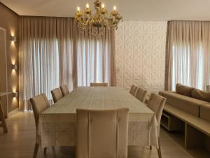 a dining room with a table and chairs and a chandelier at Casa Inteira com 3 Quartos in São Luís