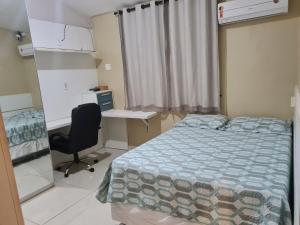 Schlafzimmer mit einem Bett, einem Schreibtisch und einem Stuhl in der Unterkunft Casa Inteira com 3 Quartos in São Luís