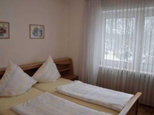 um quarto com uma cama com almofadas e uma janela em Ferienwohnung Fischer em Meersburg