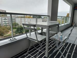 a table and two chairs on a balcony at Appartement entier in Rennes