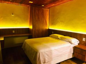 1 dormitorio con cama y pared amarilla en Gadhega's Hotel, en Salvador