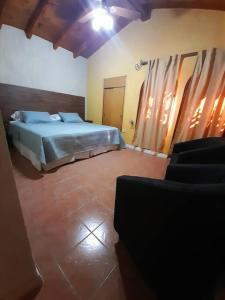 une chambre avec un lit et des chaises dans une pièce dans l'établissement Casa El Encuentro, à La Cieneguita 19 autres photos