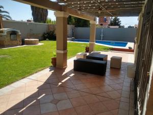a patio with a couch and chairs under a pergola at Casa El Encuentro in La Cieneguita