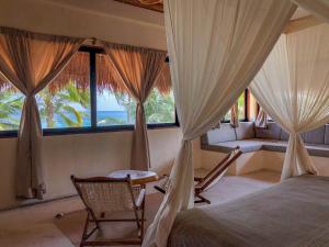 a bedroom with a bed and a couch and windows at Diamante K - Inside Tulum National Park in Tulum