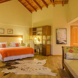 - une chambre avec un lit, un bureau et un canapé dans l'établissement Casona Del Alto, à San Martín de los Andes