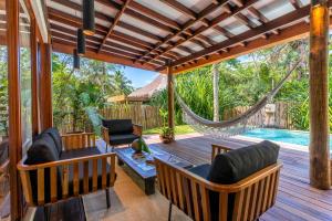 een veranda met een hangmat en een zwembad bij Camurim Grande in Maragogi