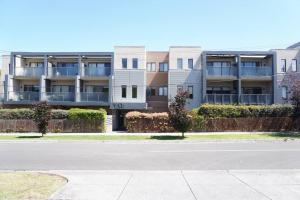 an empty street in front of an apartment building at ViQi Two bedroom apartment front of century walk Including Premium NETFLIX & Prime AMAZON with 75 INCH TV in Glen Waverley