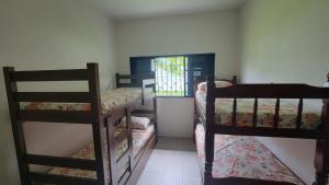 a room with three bunk beds and a window at Casa de praia - São Sebastião in São Sebastião