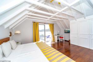um quarto com uma cama branca e um tecto amarelo e branco em Villa DAHOUET em Saint Barthelemy