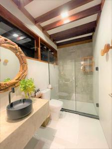 een badkamer met een douche, een wastafel en een toilet bij Camurim Grande in Maragogi