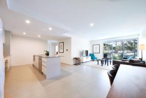 an open living room with a kitchen and a dining room at Tranquility the Beach in Huskisson