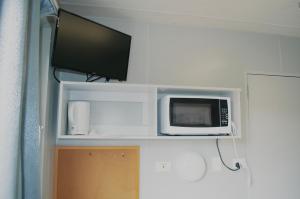eine Mikrowelle auf einem Regal mit einem TV darauf in der Unterkunft Art Shack @ Wilgabah in Wallabadah