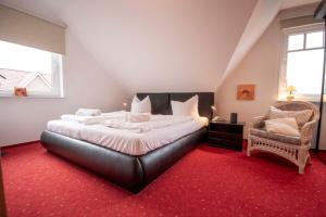 een slaapkamer met een groot bed en een stoel bij Ferienhaus-Haus-Eversand in Cuxhaven