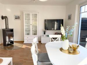 een woonkamer met een witte tafel en een open haard bij Ferienhaus-Haus-Eversand in Cuxhaven