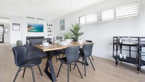 a dining room with a table and chairs at Luxe by the Lake in Lake Illawarra